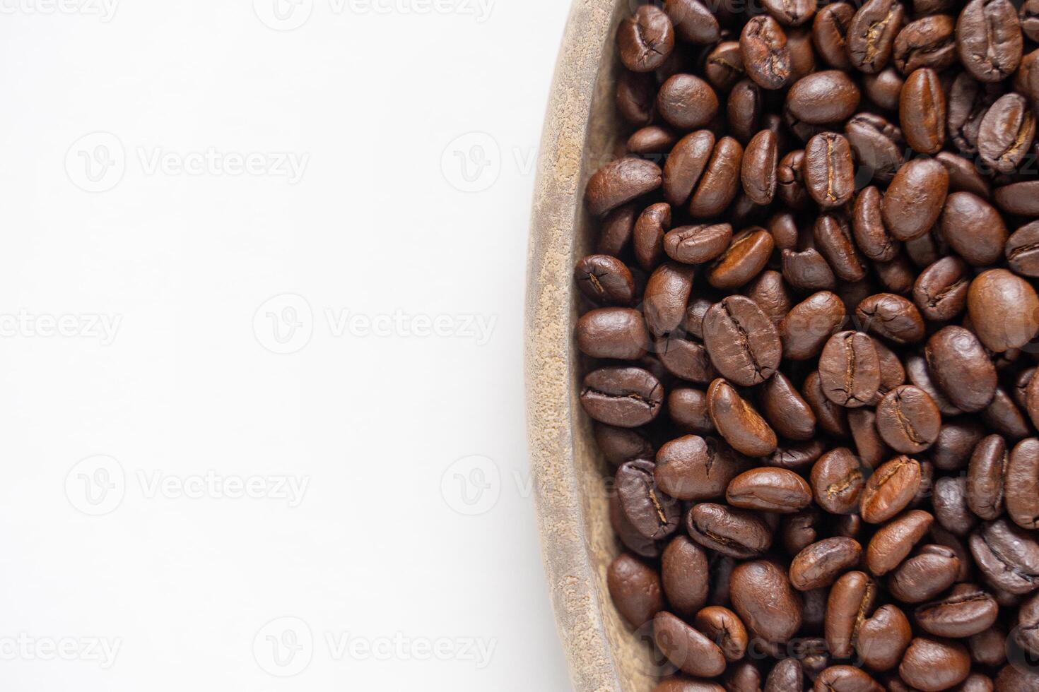 Coffee beans and wooden plate on white background. Top view of brown roasted coffee beans. Close up image. photo