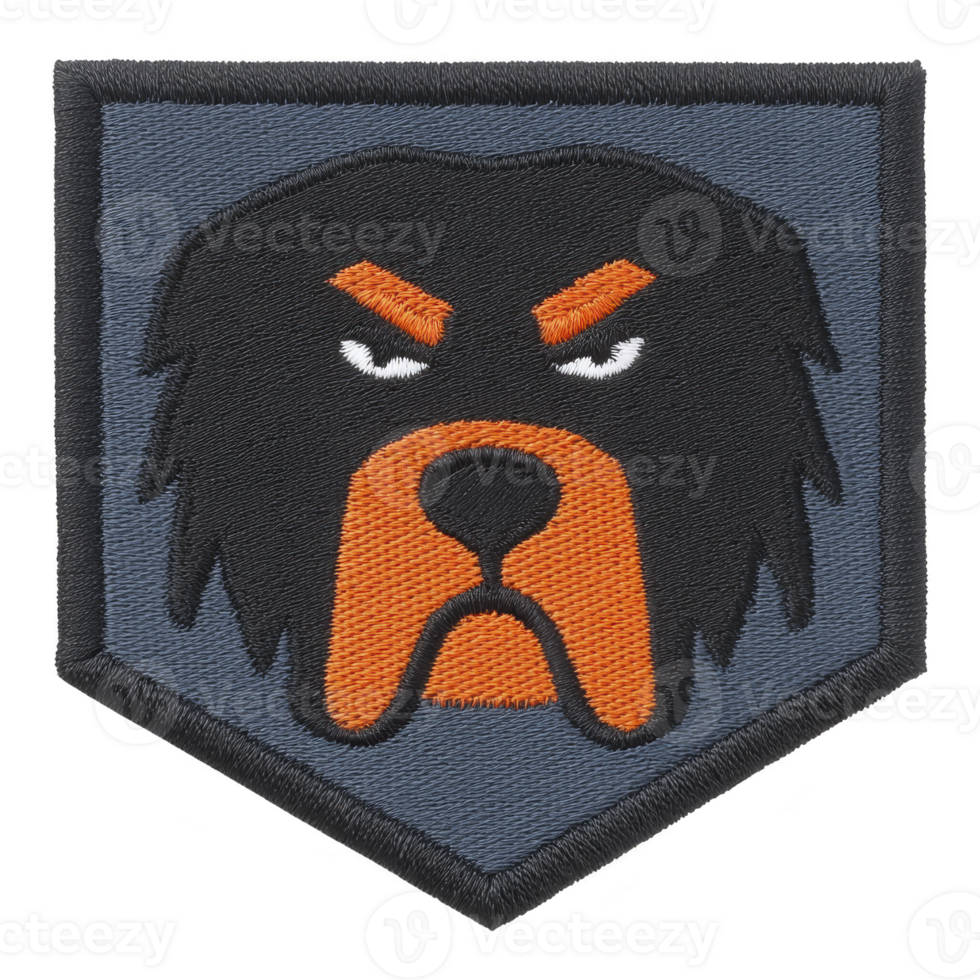 This features embroidered patch with stylized dog face design. patch has shield shape with transparency background, showcasing dog face with orange and black details, giving intense expression png