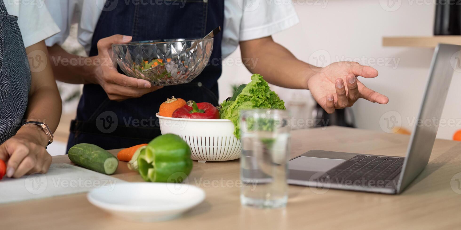 Couple Discussing Recipes. Engaging in a cooking session with fresh ingredients and technology. photo