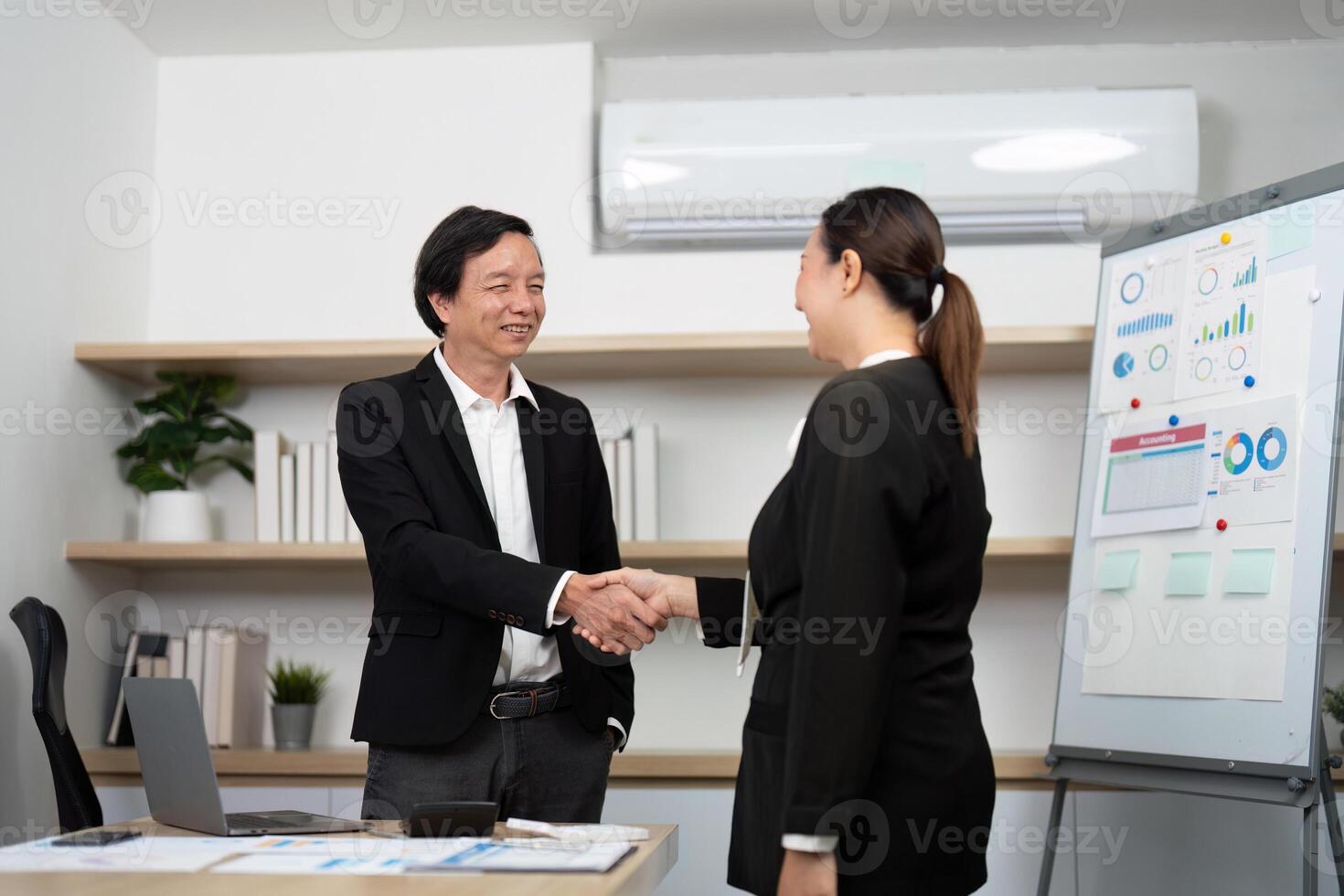 Professional Networking and Agreement. Business partners shaking hands in a modern office setting. photo