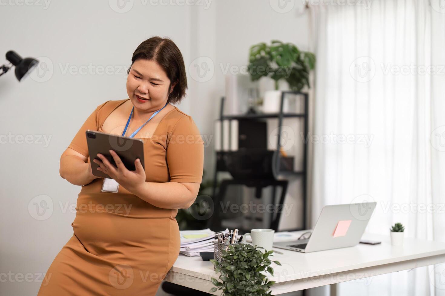 Confident Business Woman Using Tablet in Modern Office Setting with Professional Attire and Positive Attitude photo