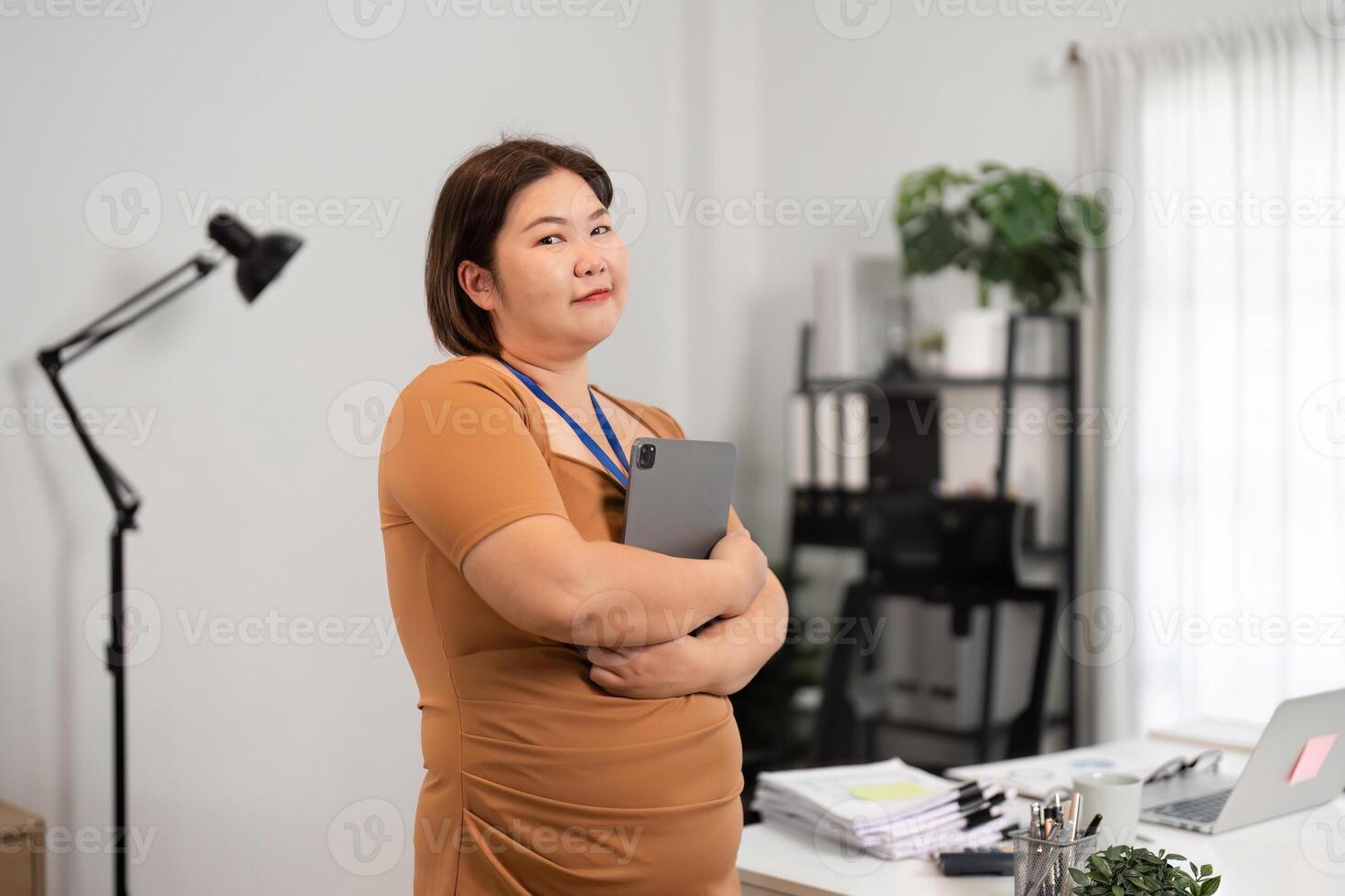 Confident Business Woman Holding Tablet in Modern Office Setting with Professional Attire and Positive Expression photo