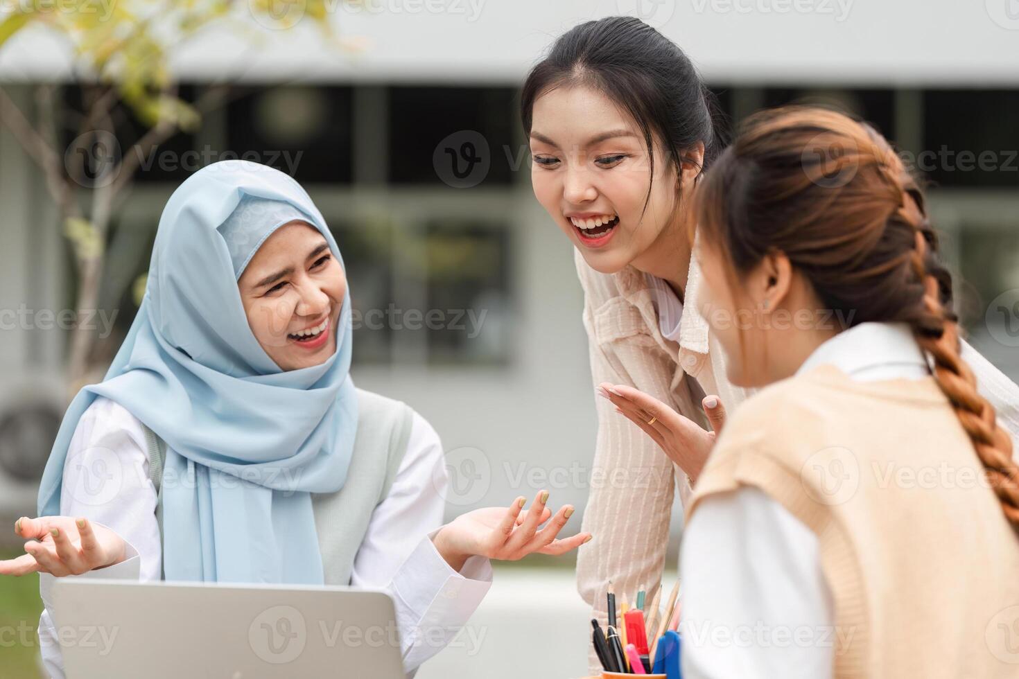 Joyful diverse women discussing ideas and studying together outdoors. photo