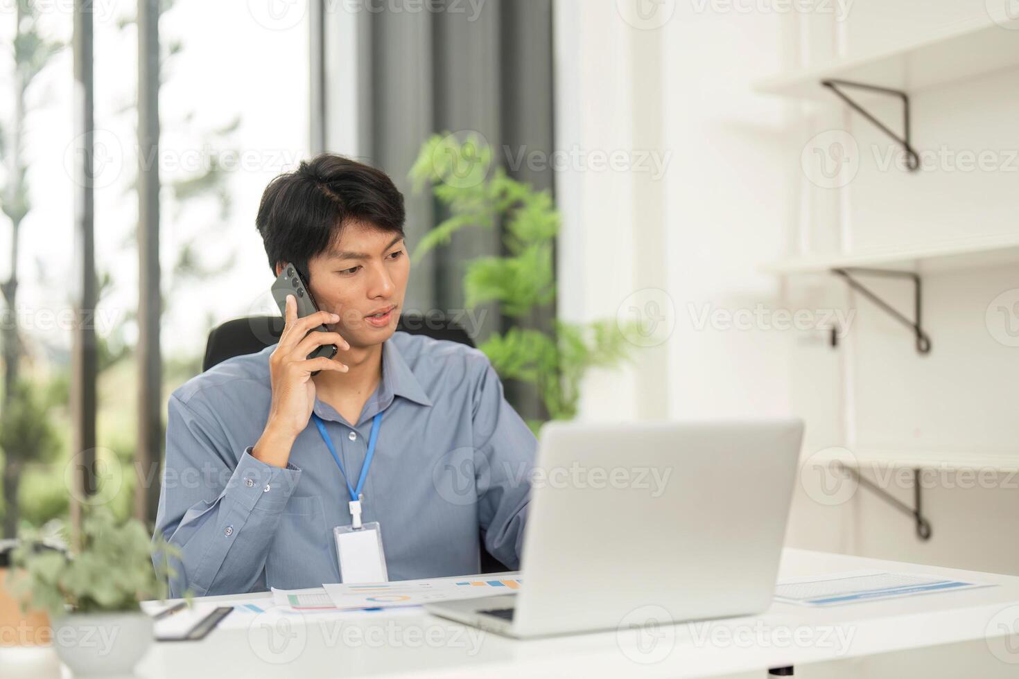 Remote Work and Professionalism. Young professional on the phone while reviewing documents. photo