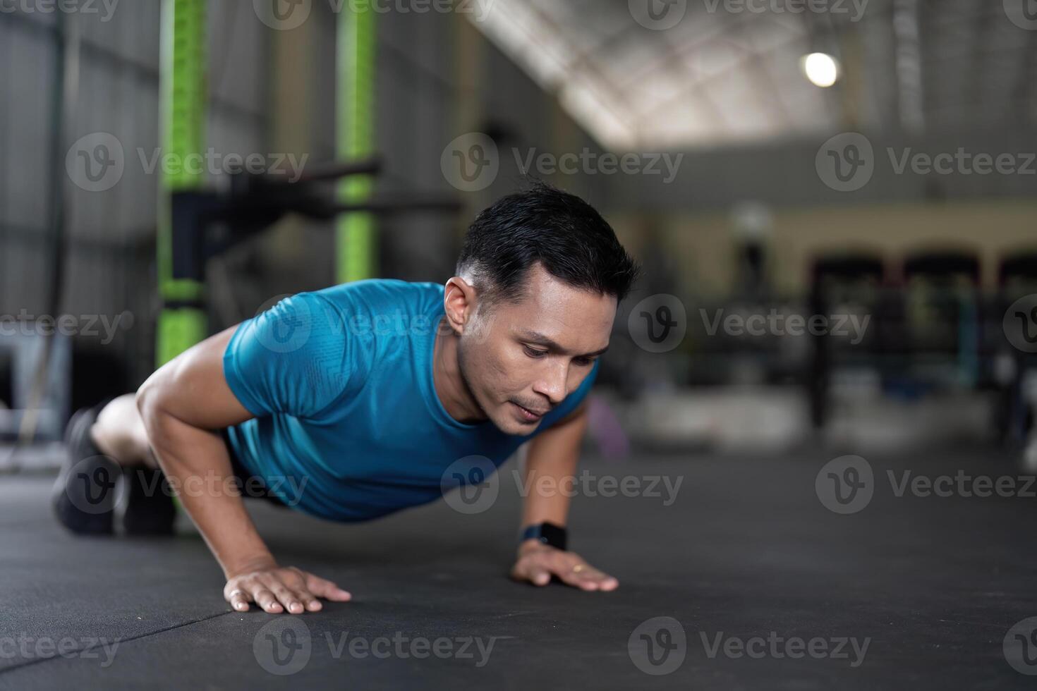 Fitness. Man Engaged in Push-Up Exercise at Gym photo