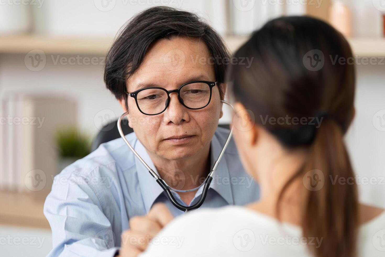 Doctor Using Stethoscope for Patient Checkup. Physician examining patient with a stethoscope. photo