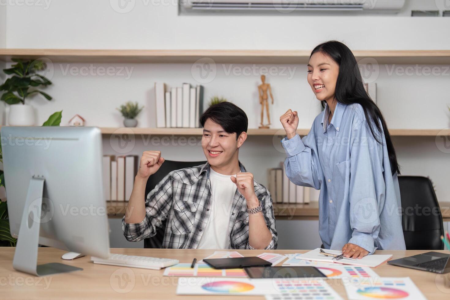 Joyful Designers in UX and UI. Two colleagues celebrate their success with excitement in a modern office. photo