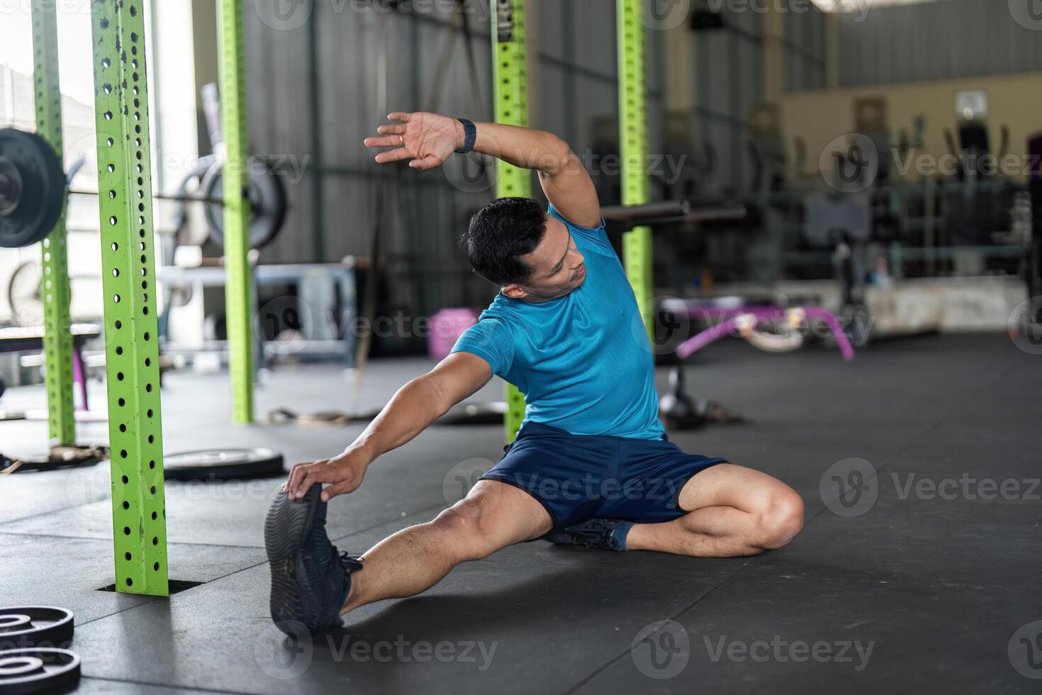 Fitness and Flexibility. Man stretching his side in a gym for improved mobility. photo