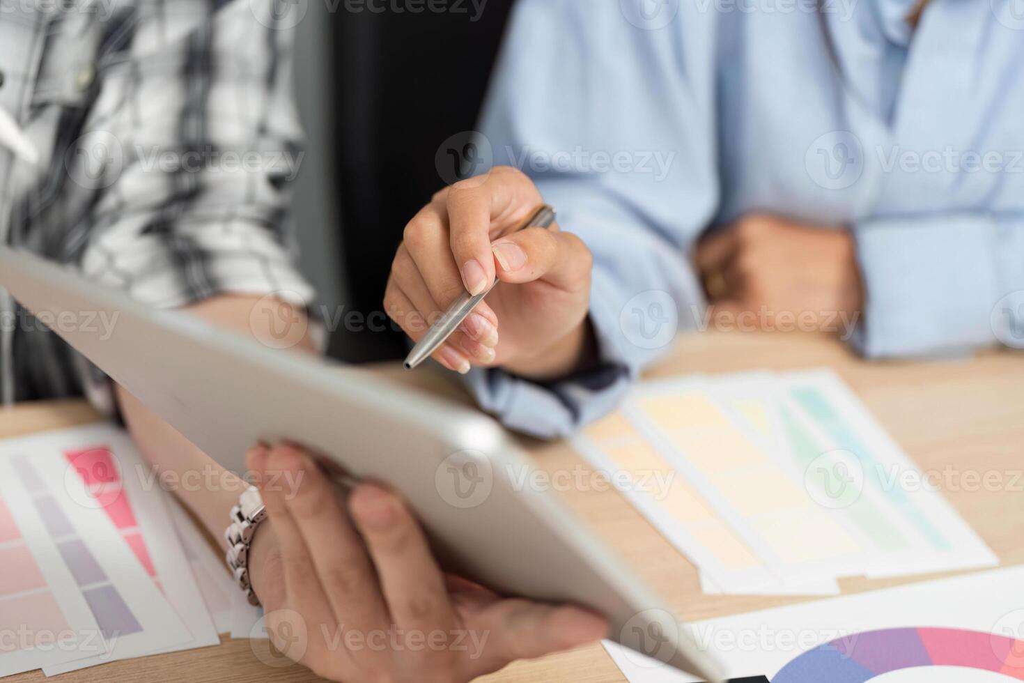 UX and UI Design Tools. Hands holding a tablet while discussing design options. photo