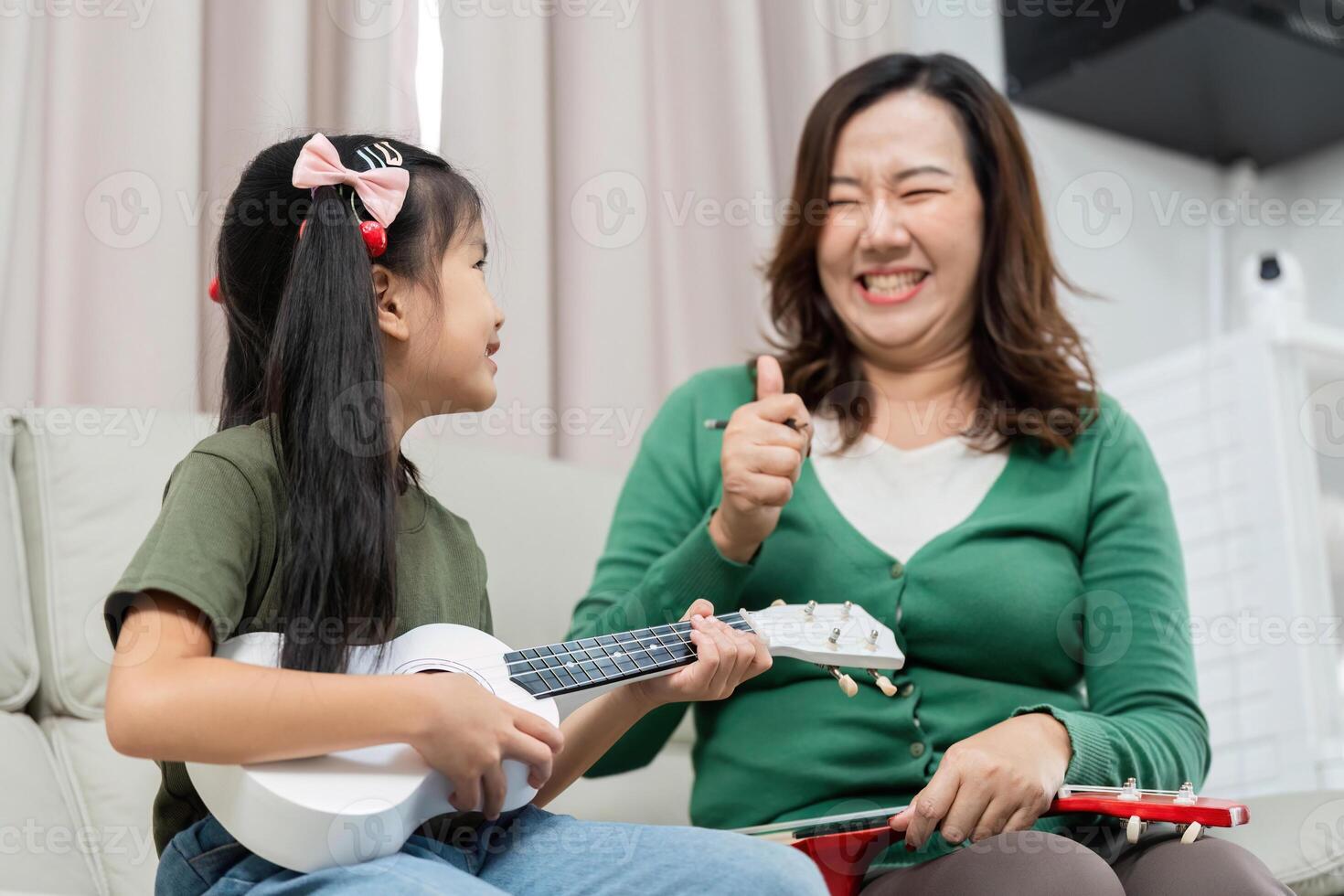 Encouragement in Music. A mother celebrates her daughter's ukulele progress with a thumbs up. photo