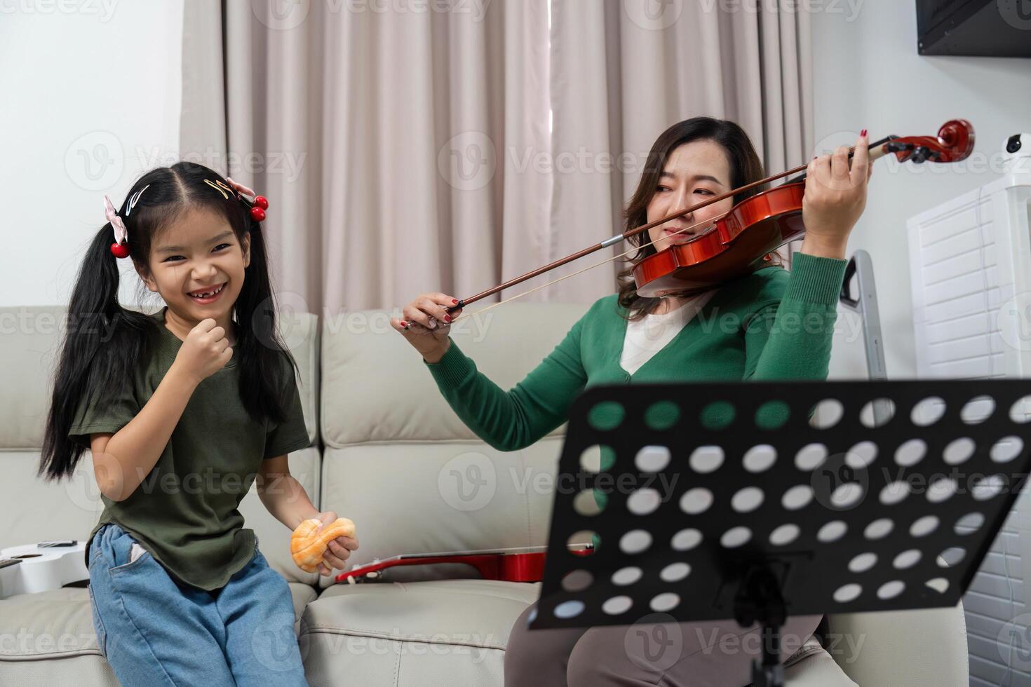 Learning Violin Together. Mother and daughter enjoying music at home. photo