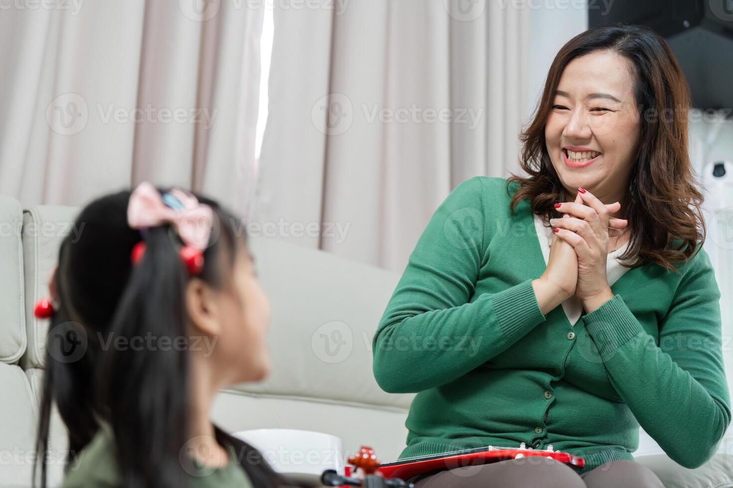 Music Education and Joyful Learning. A mother smiling and engaging with her daughter during a music lesson. photo