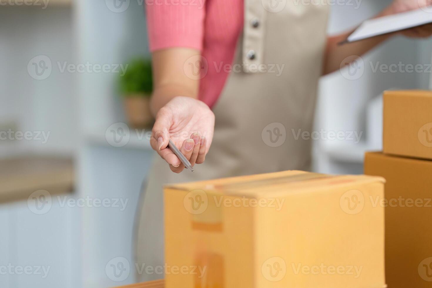 Small Business Efficiency. A woman organizing packages with a pen in hand. photo