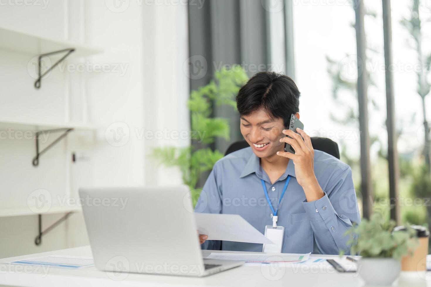 Remote Work and Communication. Young professional smiling while talking on the phone. photo