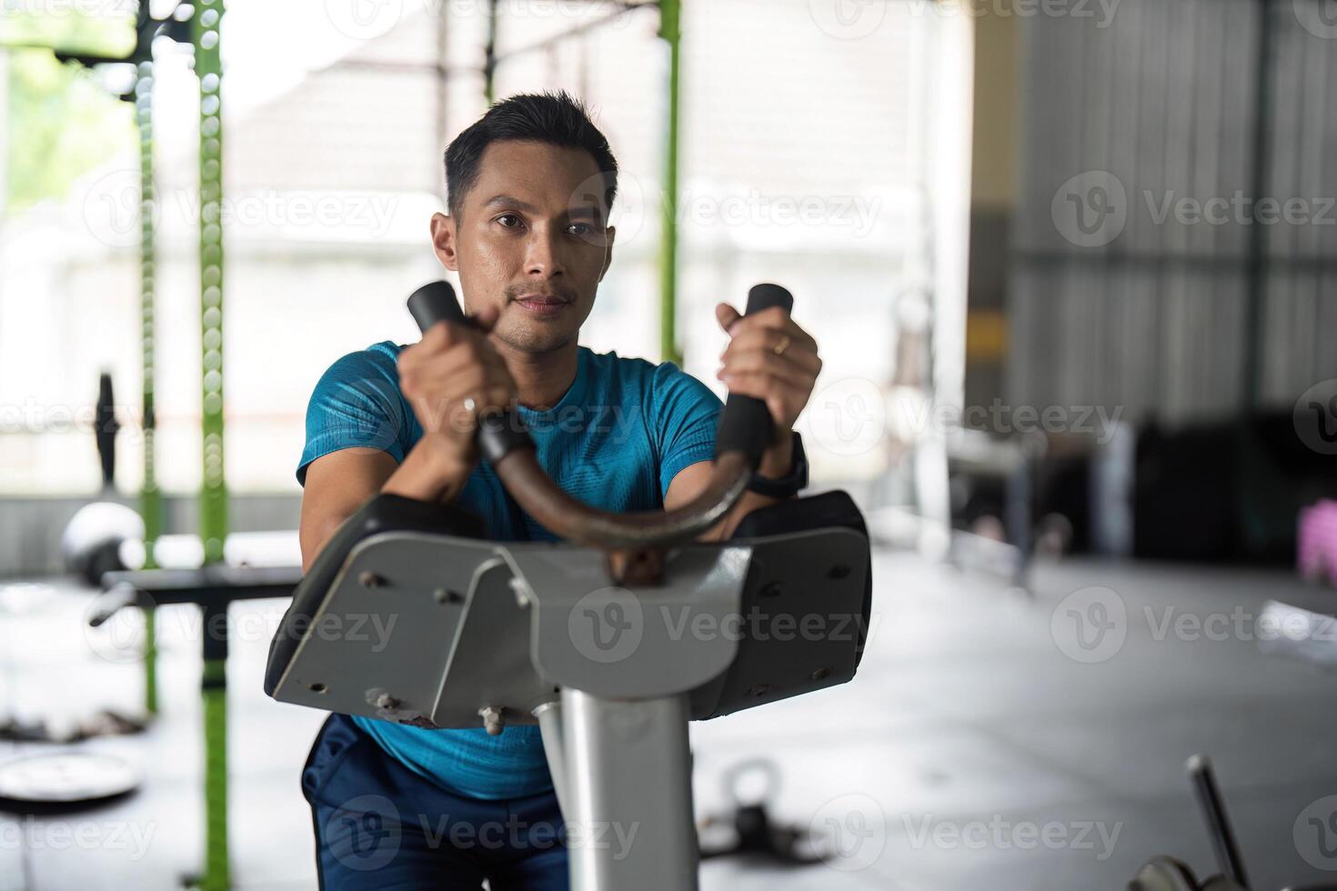 Focused Fitness. Man on elliptical machine concentrating on workout. photo