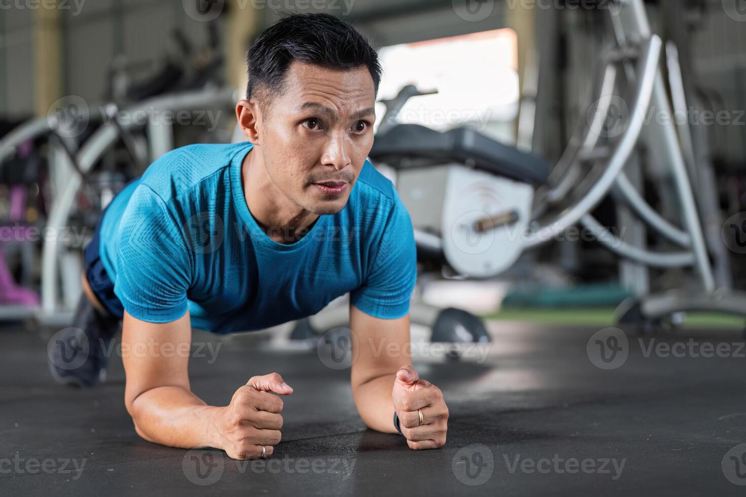 Fitness Core Strength. Man performing plank exercise in gym. photo