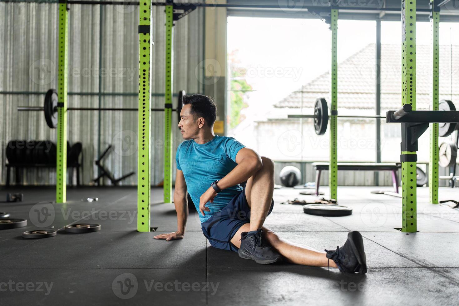 Fitness and Stretching. Man in a gym performing a seated stretch. photo