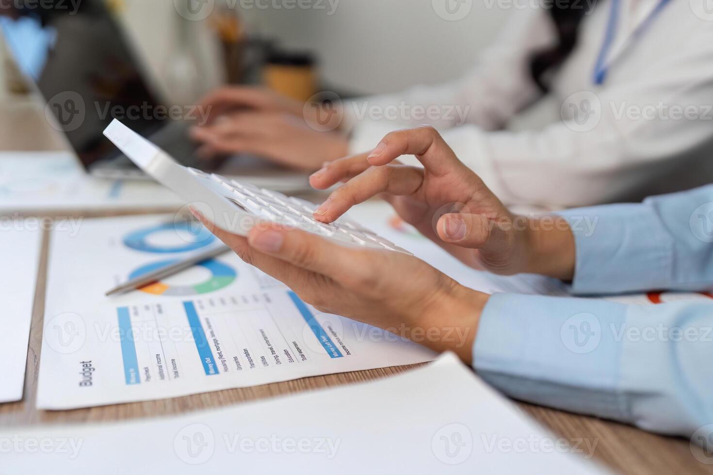 Budget Planning Session. A woman using a calculator while reviewing financial documents. photo