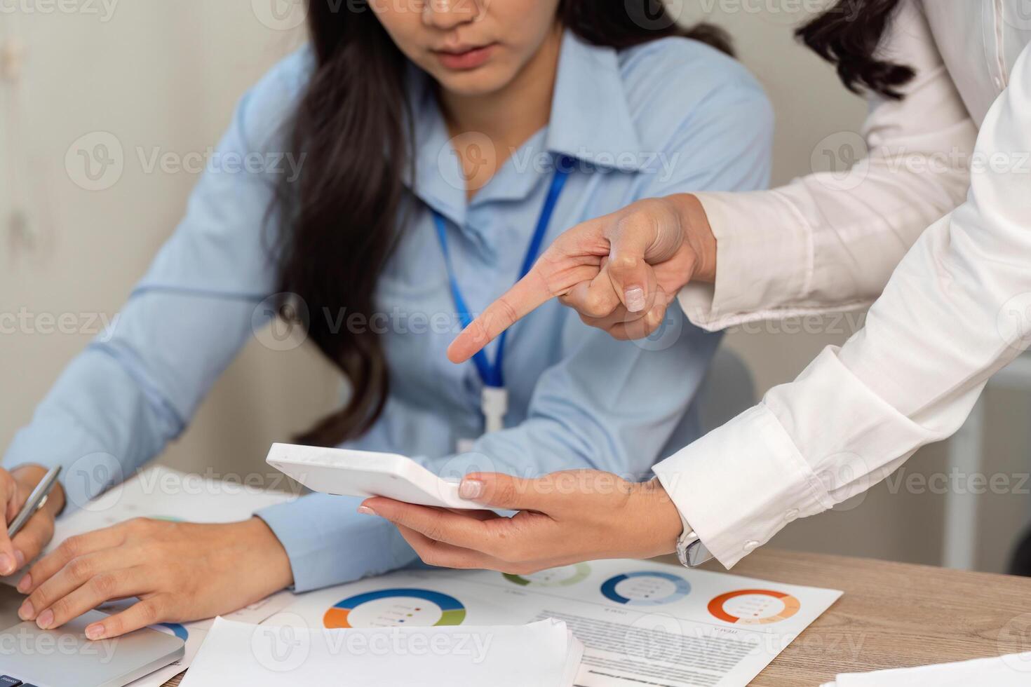 Data Review Session. Businesswomen discussing financial data on a tablet. photo