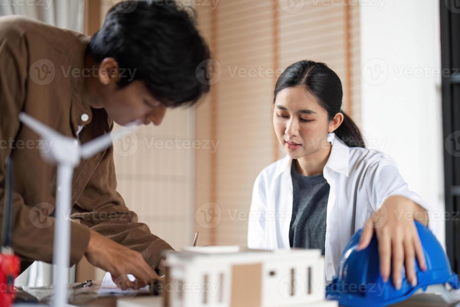 ESG Principles in Action. Young architects collaborating on sustainable building design. photo