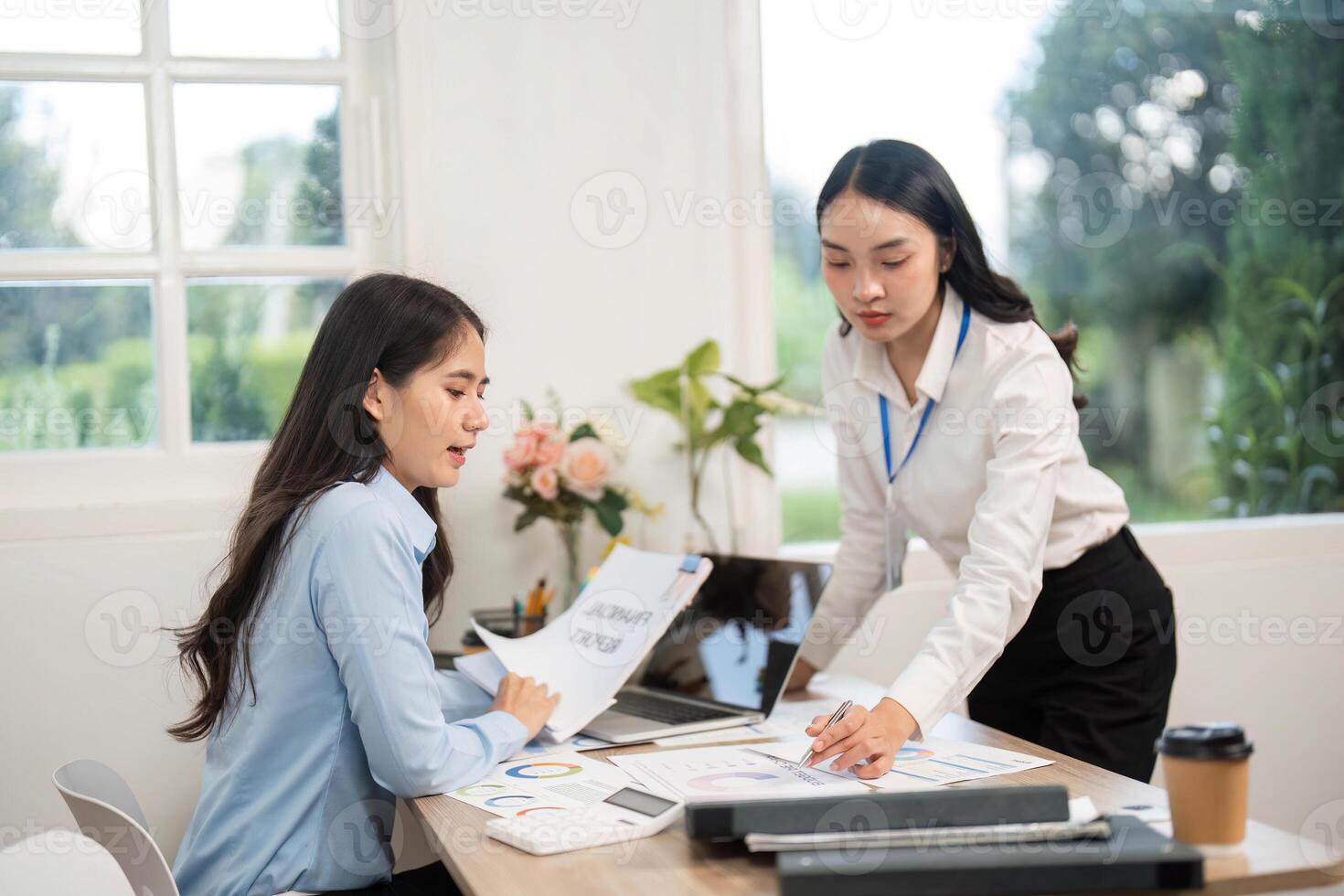 Collaboration and Communication. Two businesswomen discussing project details in a modern office. photo