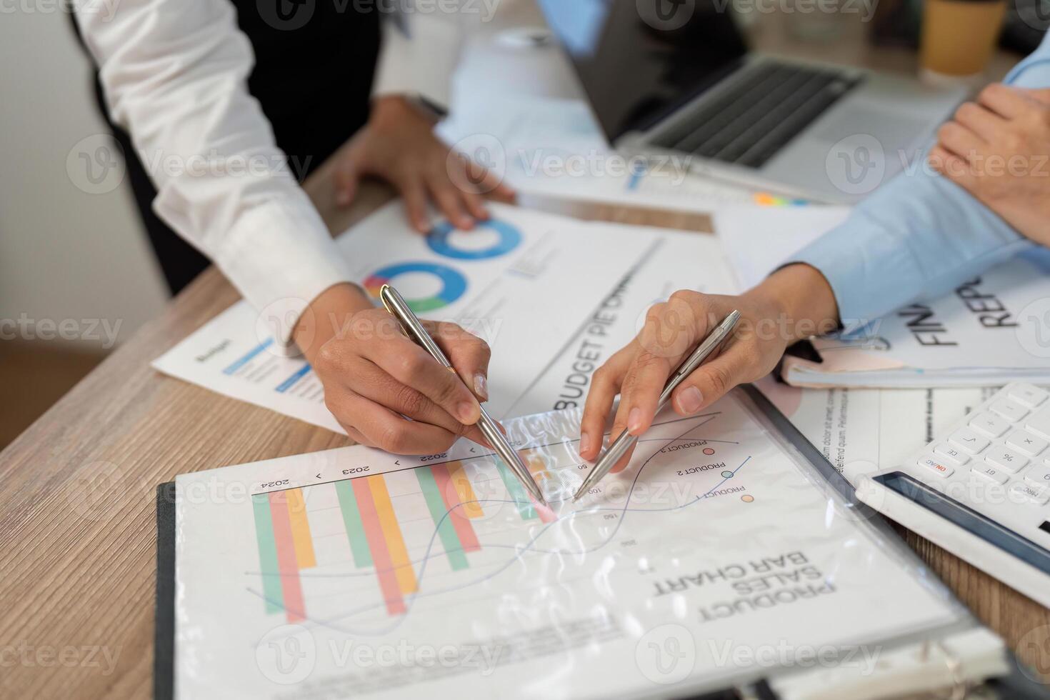 Financial Analysis. Close-up of hands reviewing budget charts and graphs at desk. photo