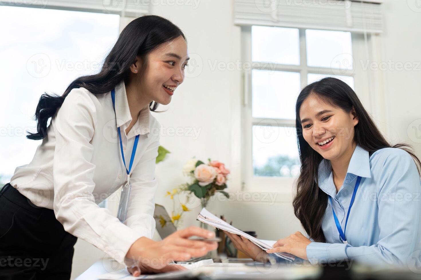 Teamwork in Action. Two businesswomen discussing financial documents at office table. photo