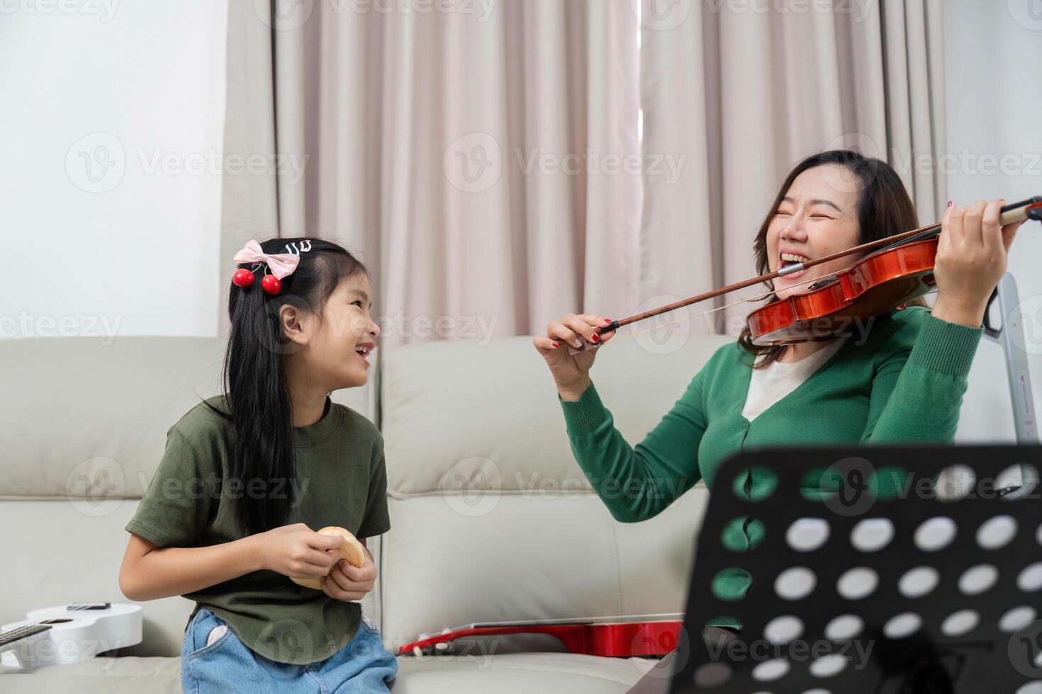 Joyful Music Practice. Child and mother enjoying violin lessons at home. photo