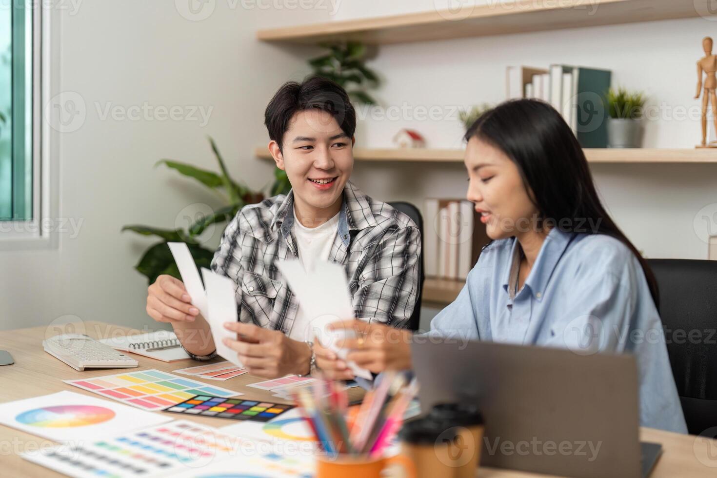 UX and UI Design Interaction. Young creatives analyzing color samples and discussing layout options in a bright office. photo