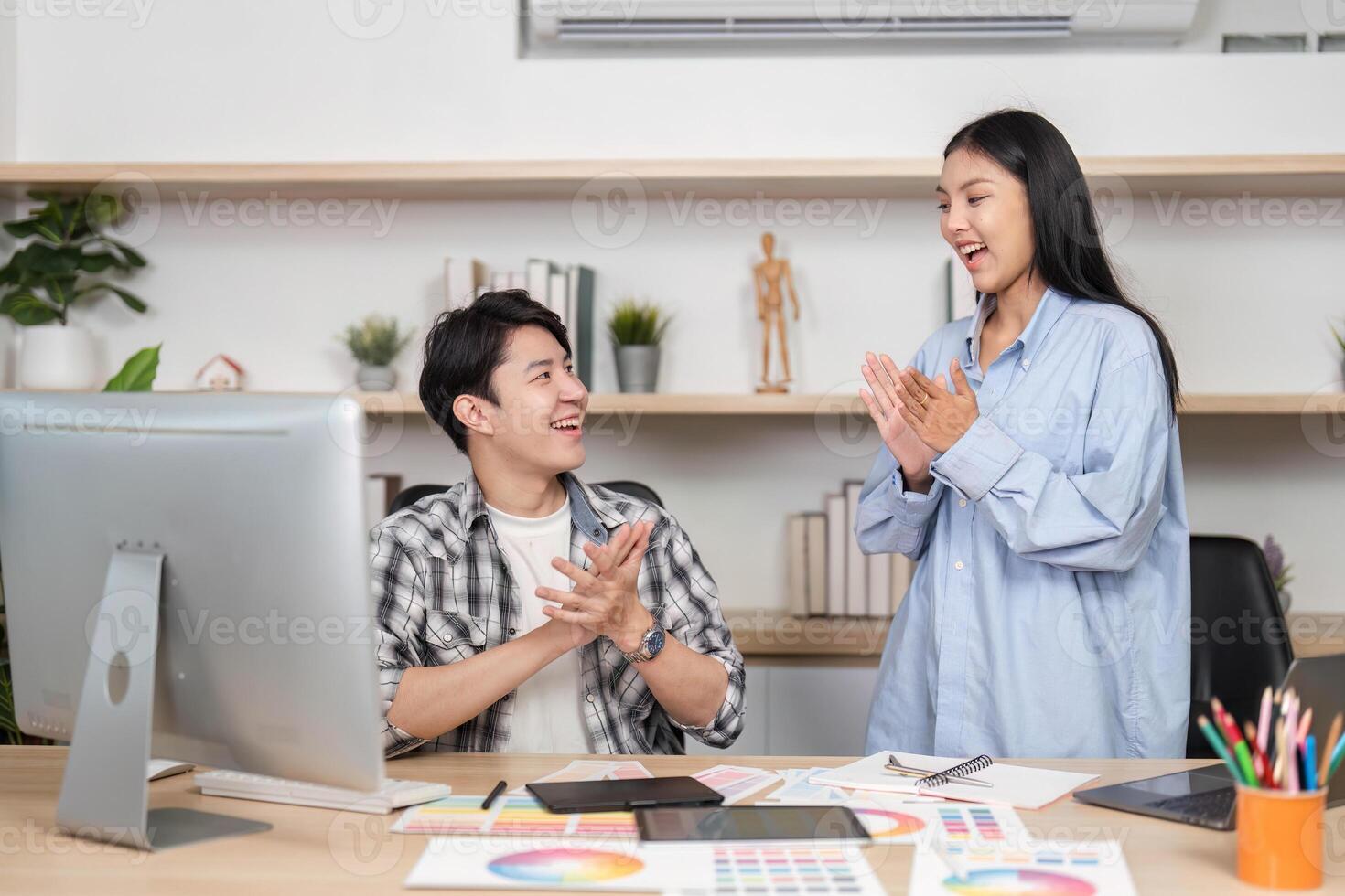 UX and UI Design Celebration. Two designers express excitement over project progress in a vibrant workspace. photo
