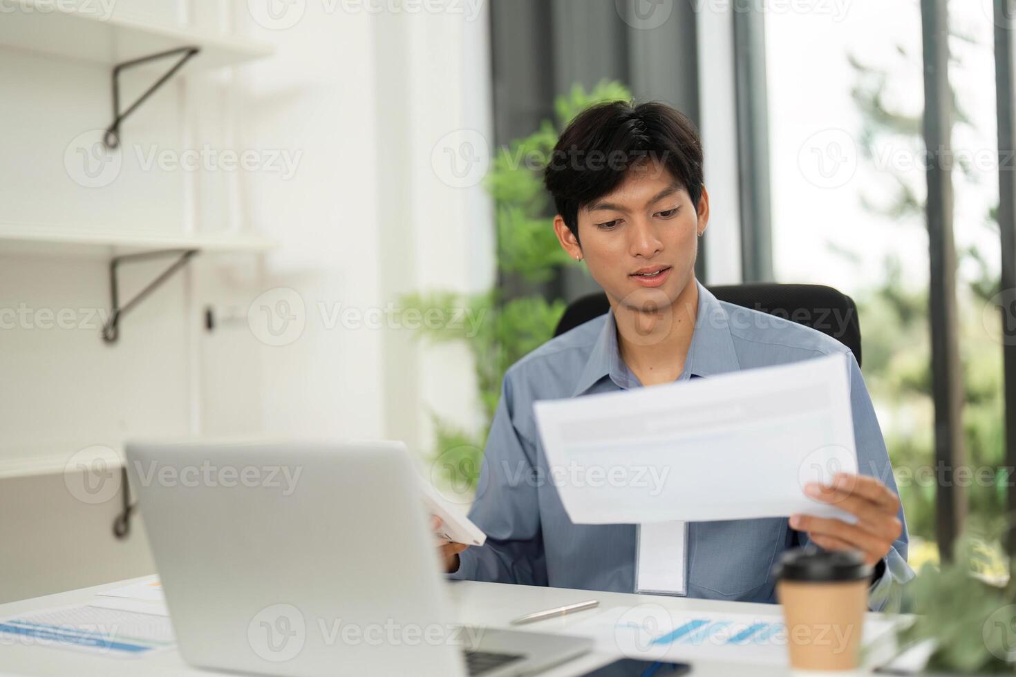 Remote Work and Professionalism. Young businessman reviewing documents while working from home. photo