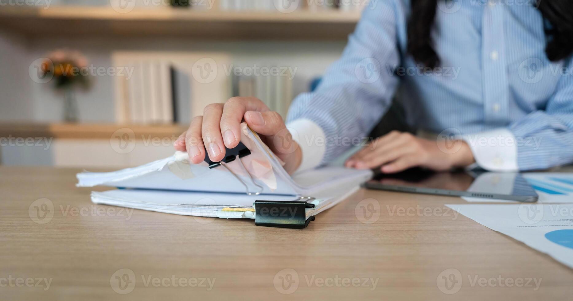 Office Organization. Close-up of a woman organizing documents with a binder in a modern workspace. photo