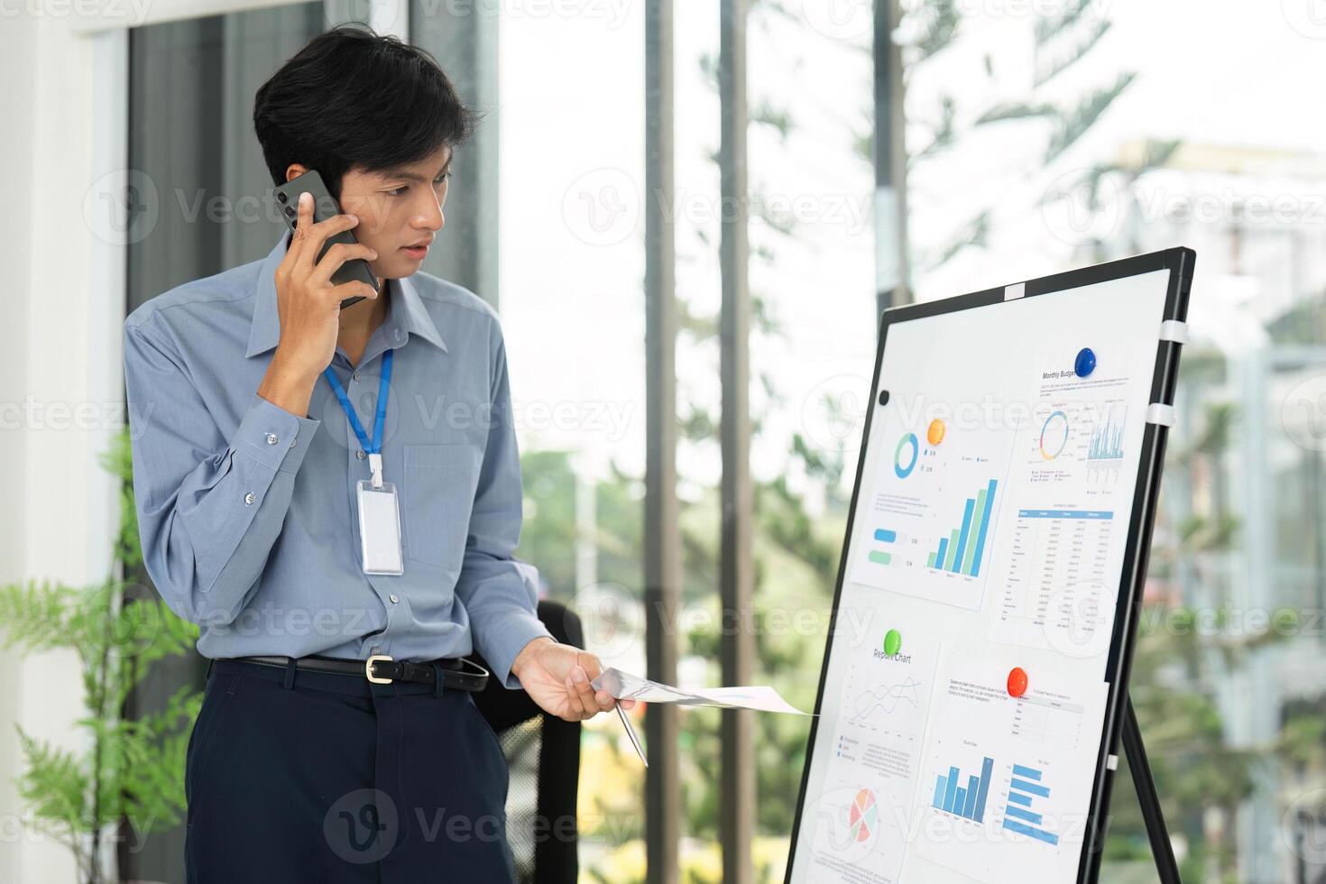 Business Presentation and Analysis. Professional man discussing data on a whiteboard while on a phone call. photo