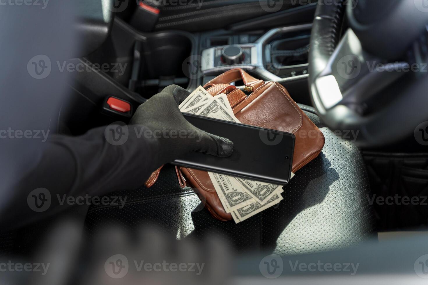 Thief stealing phone and money from purse on car seat, concept of crime, robbery, danger, and insecurity photo