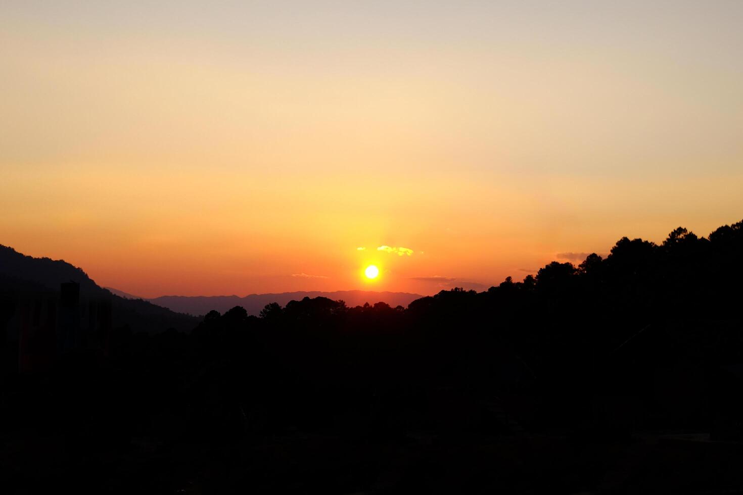 Beautiful landscape of dramatic sky with sunset shining over the silhouette valley mountain in Thailand photo