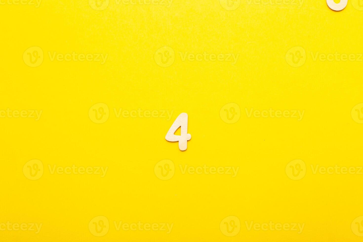 Top view of wooden number 4 four on yellow bright background. photo