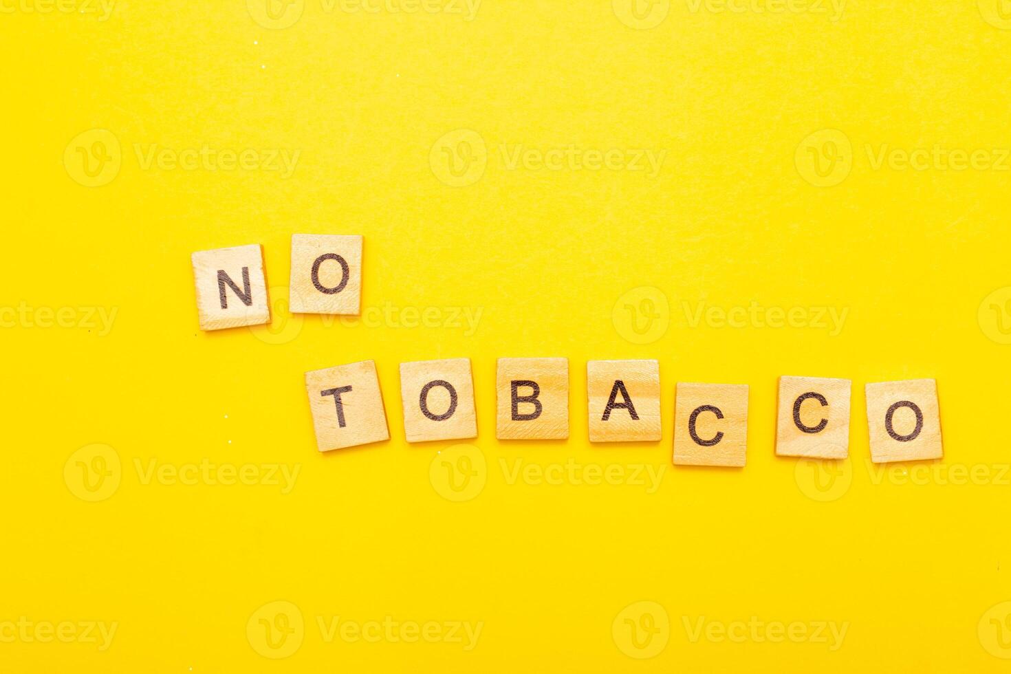Top view of word no tabaco on a yellow background closeup. photo