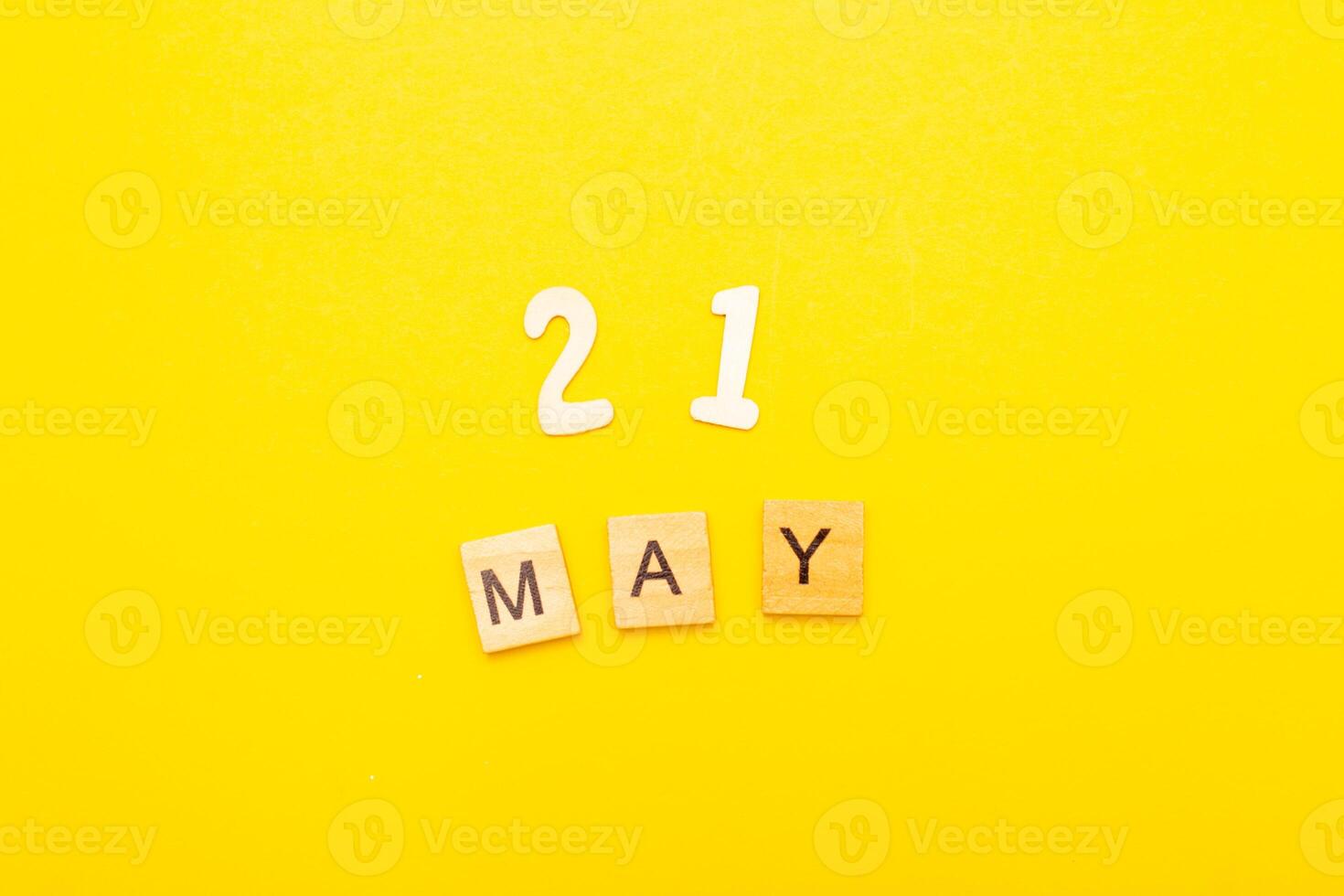 Top view of word 21 May calendar date made by wooden cubes on yellow color background photo