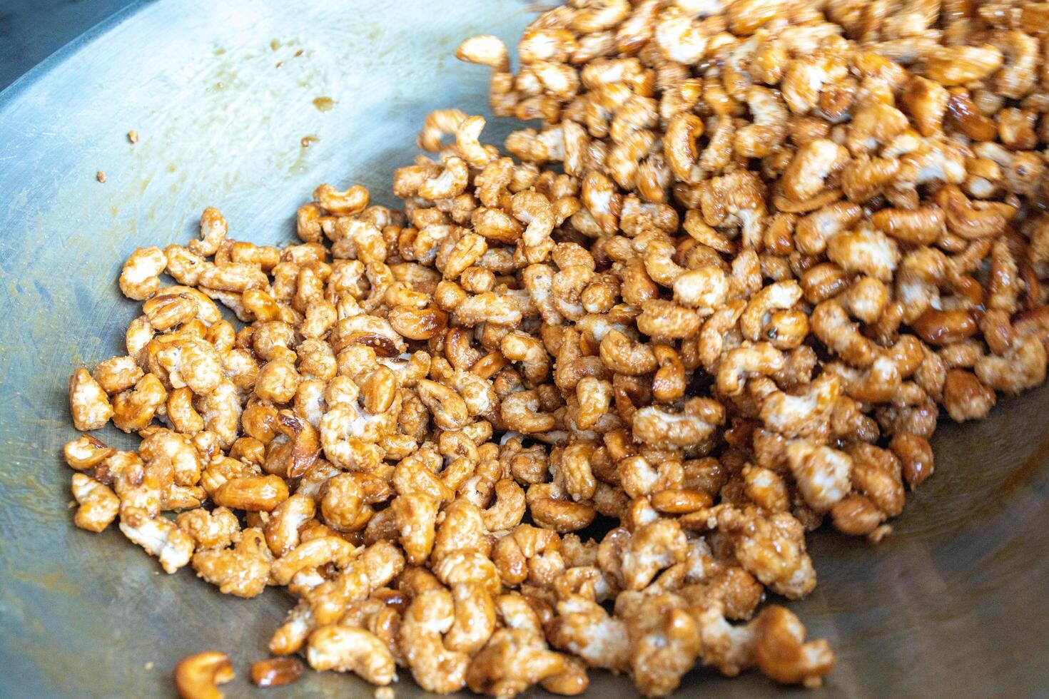 Macro Closeup of Cashew nuts seeds and white sesame mix with sugar in a pan photo