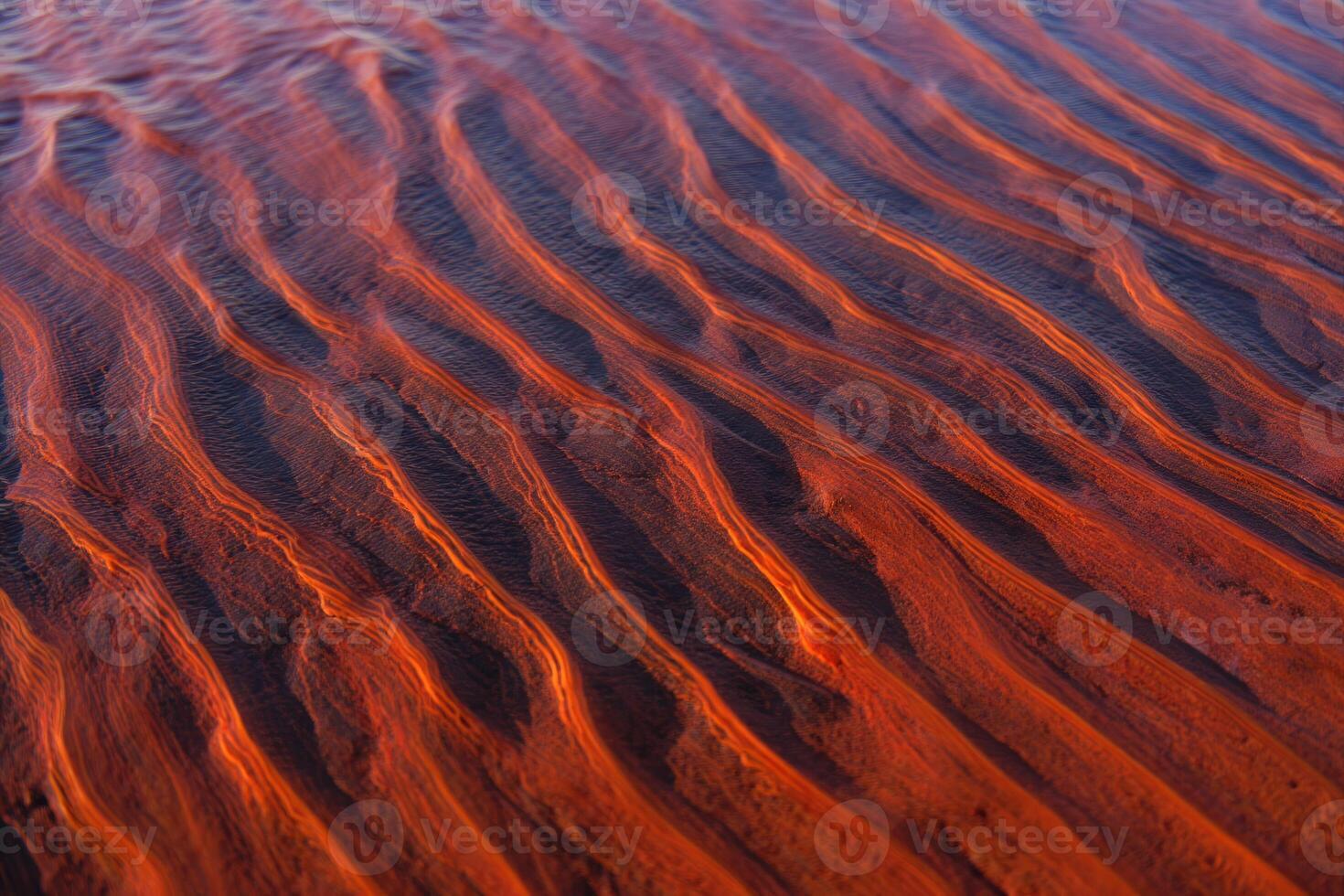 Warm sunset light illuminates the textured patterns of sand in a close up view. photo