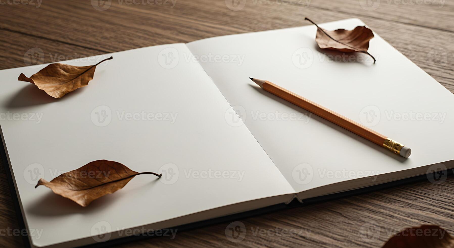 Autumn leaves on a wooden table with a pencil and notebook photo