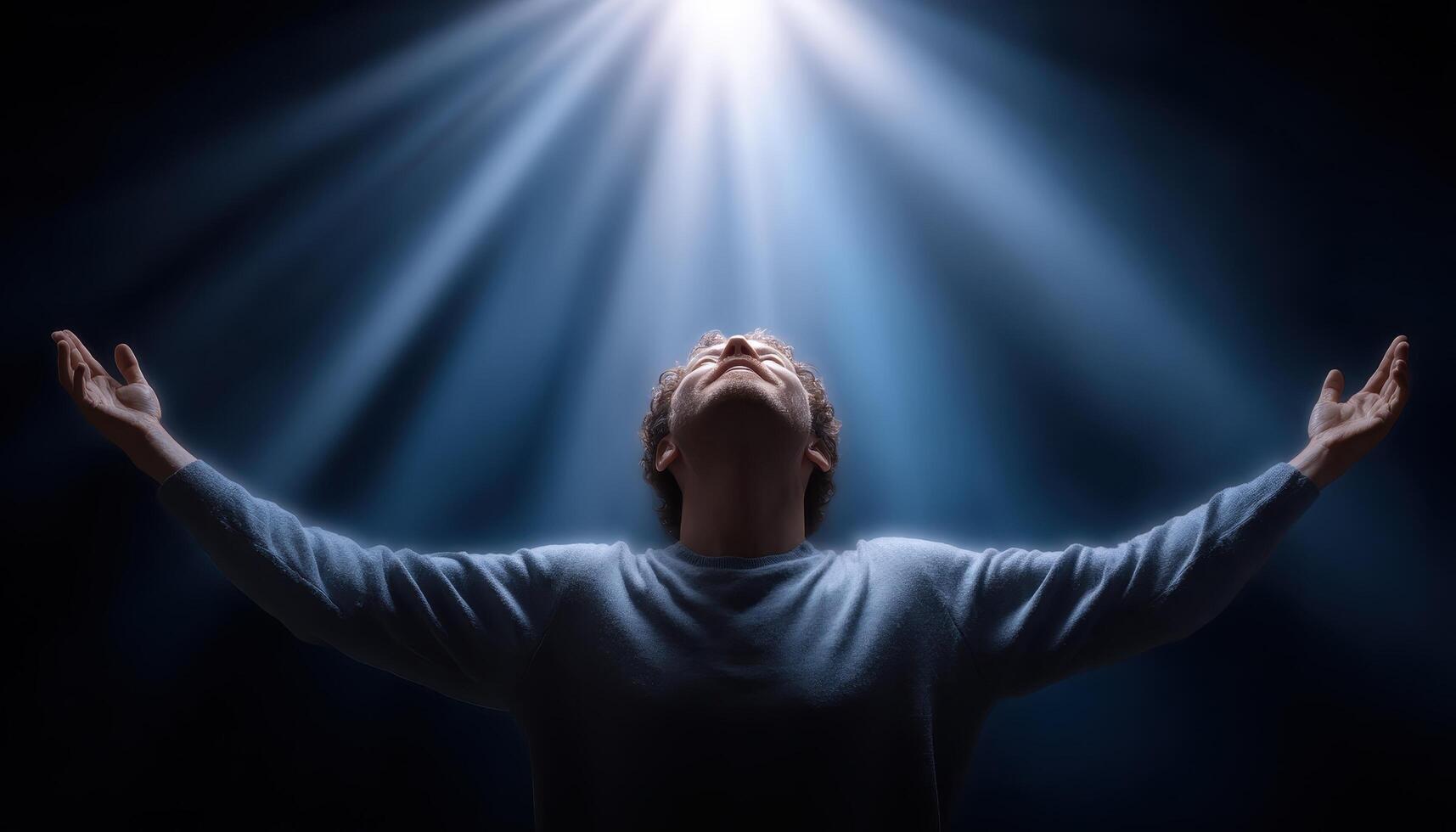 Person praying with light rays shining down in spiritual atmosphere photo