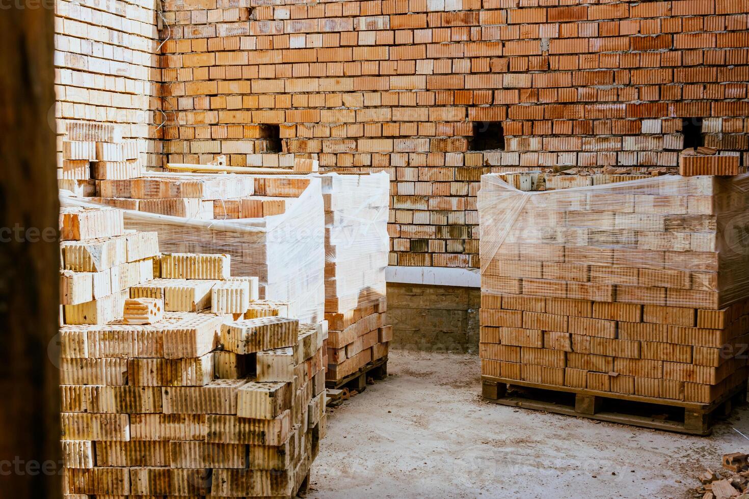 A room with stacks of bricks and pallets photo