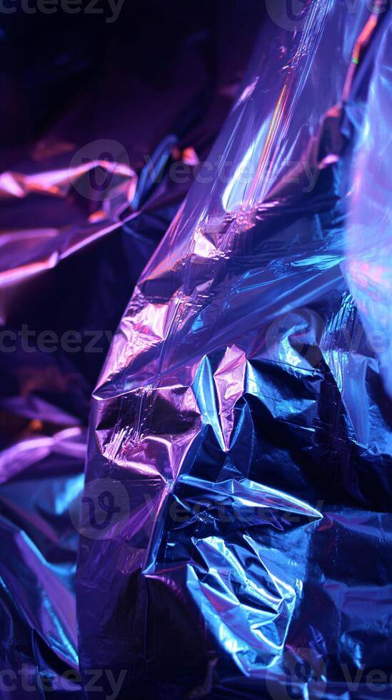 Crumpled Glossy Cellophane Shimmering Under Blue and Violet Lights photo
