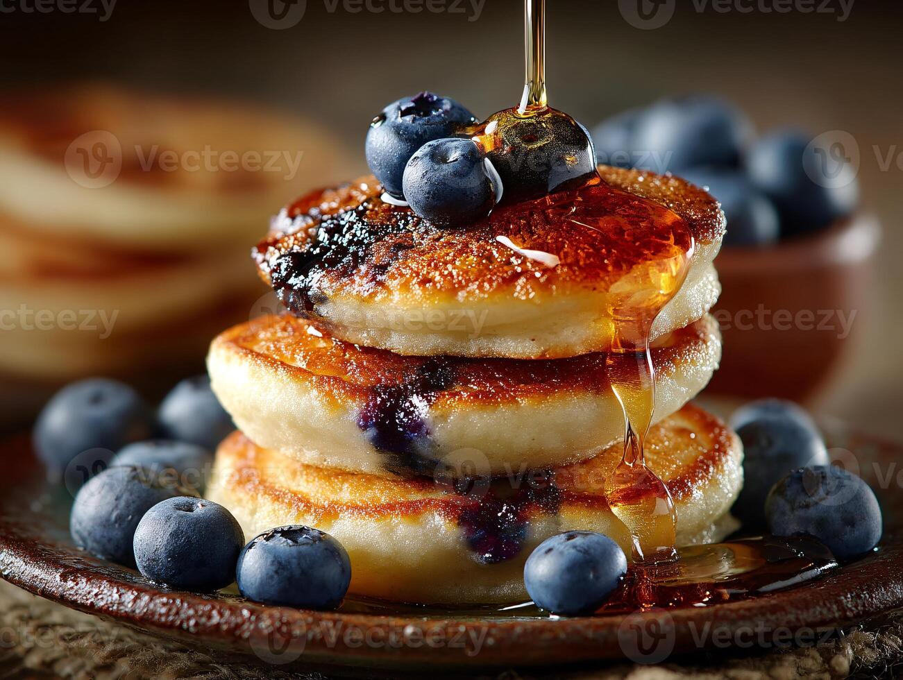 Mini pancakes stacked high with maple syrup and fresh blueberries on a plate photo