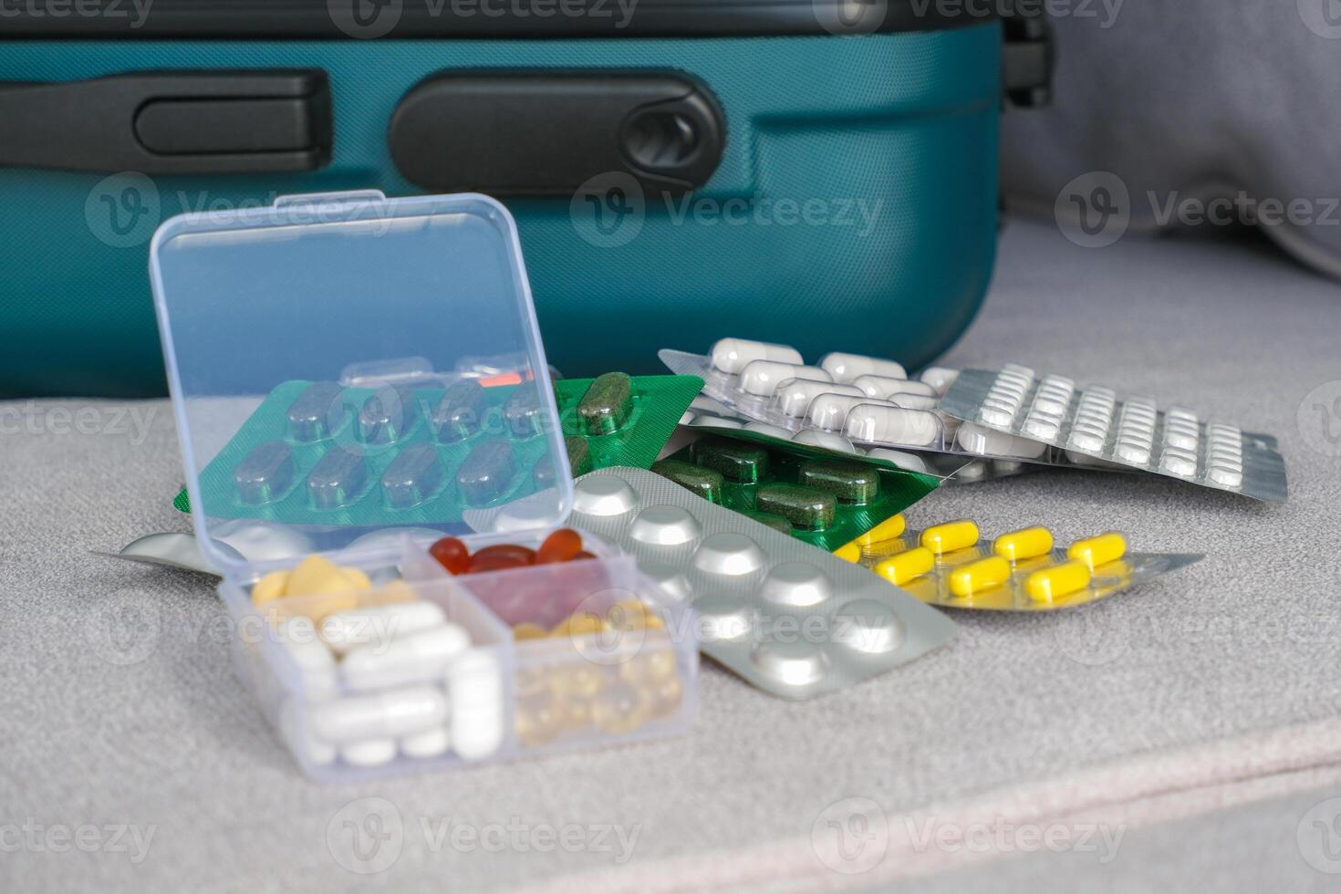 Pills in a suitcase. Concept of medication required in journey photo