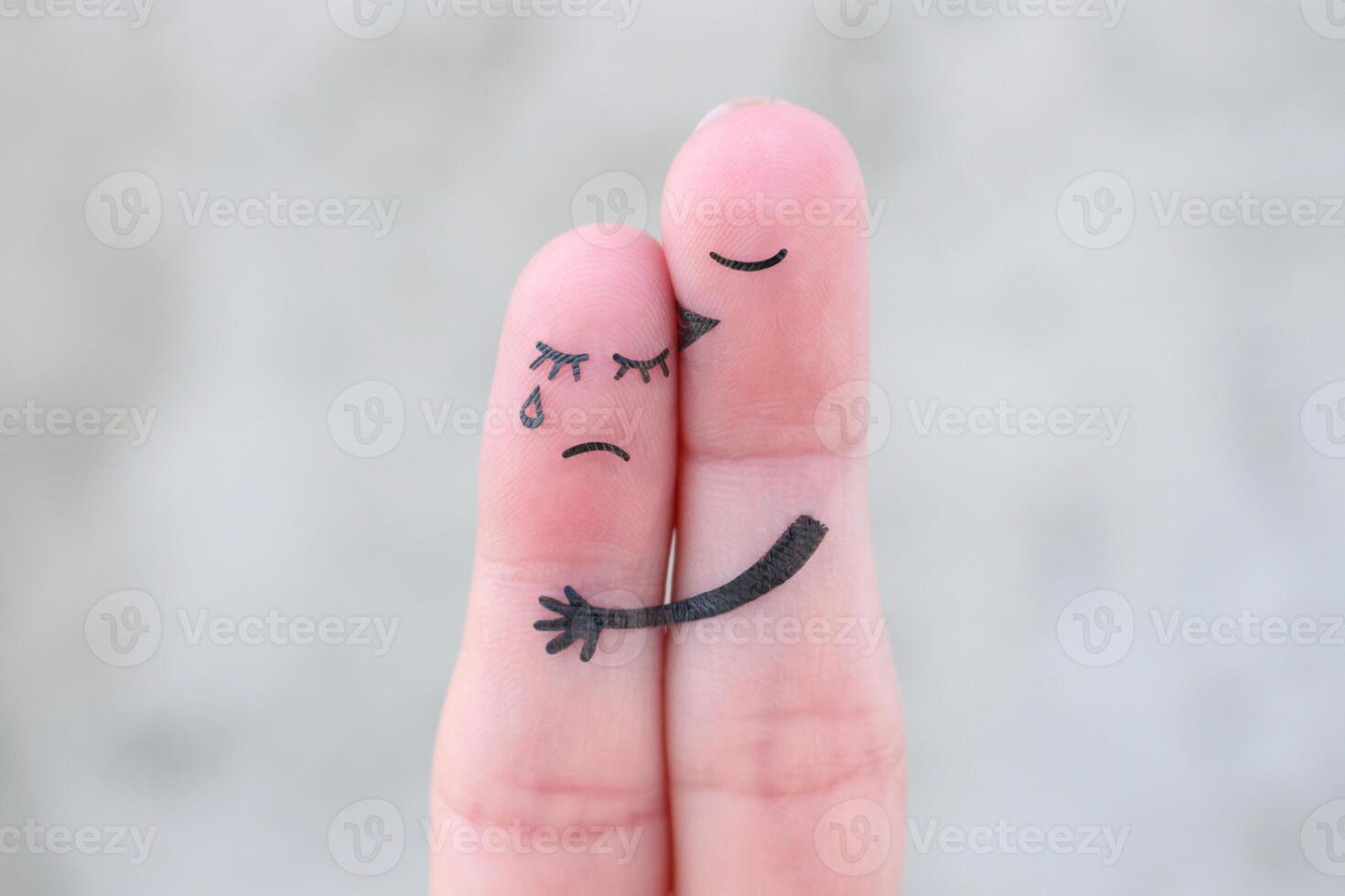 Fingers art of displeased couple. Woman cries, man reassures her. photo
