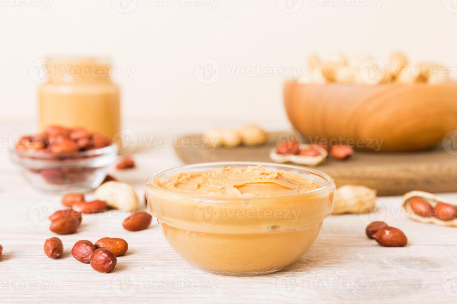 Bowl peanut butter and peanuts on table background. top view. Creamy peanut pasta photo