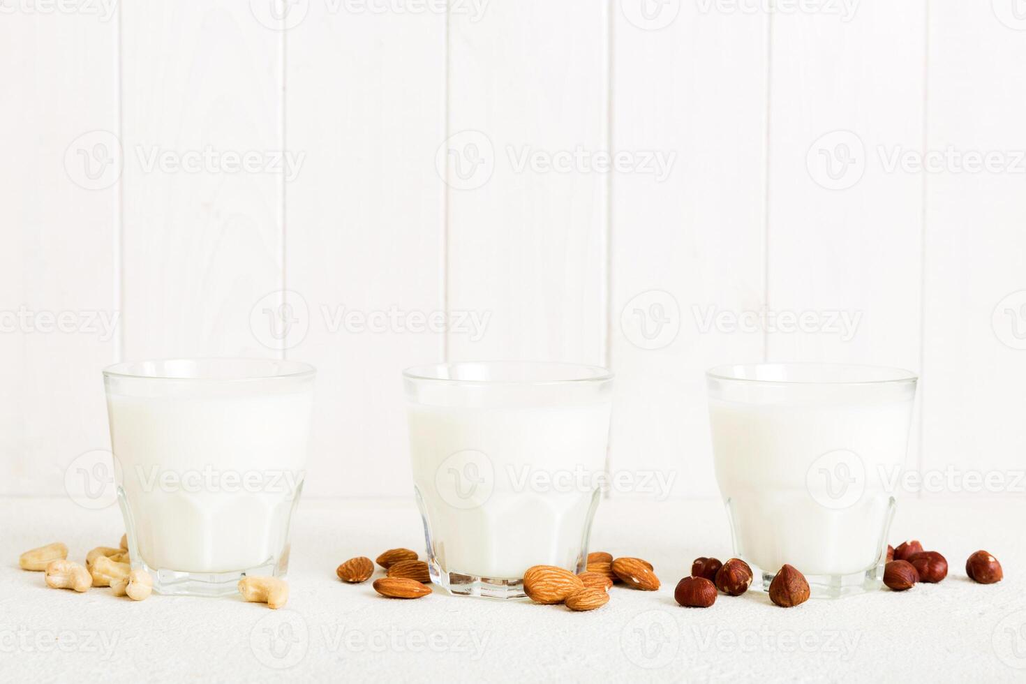 Set collection various vegan milk almond, cashew, on table background. Vegan plant based milk and ingredients, top view photo