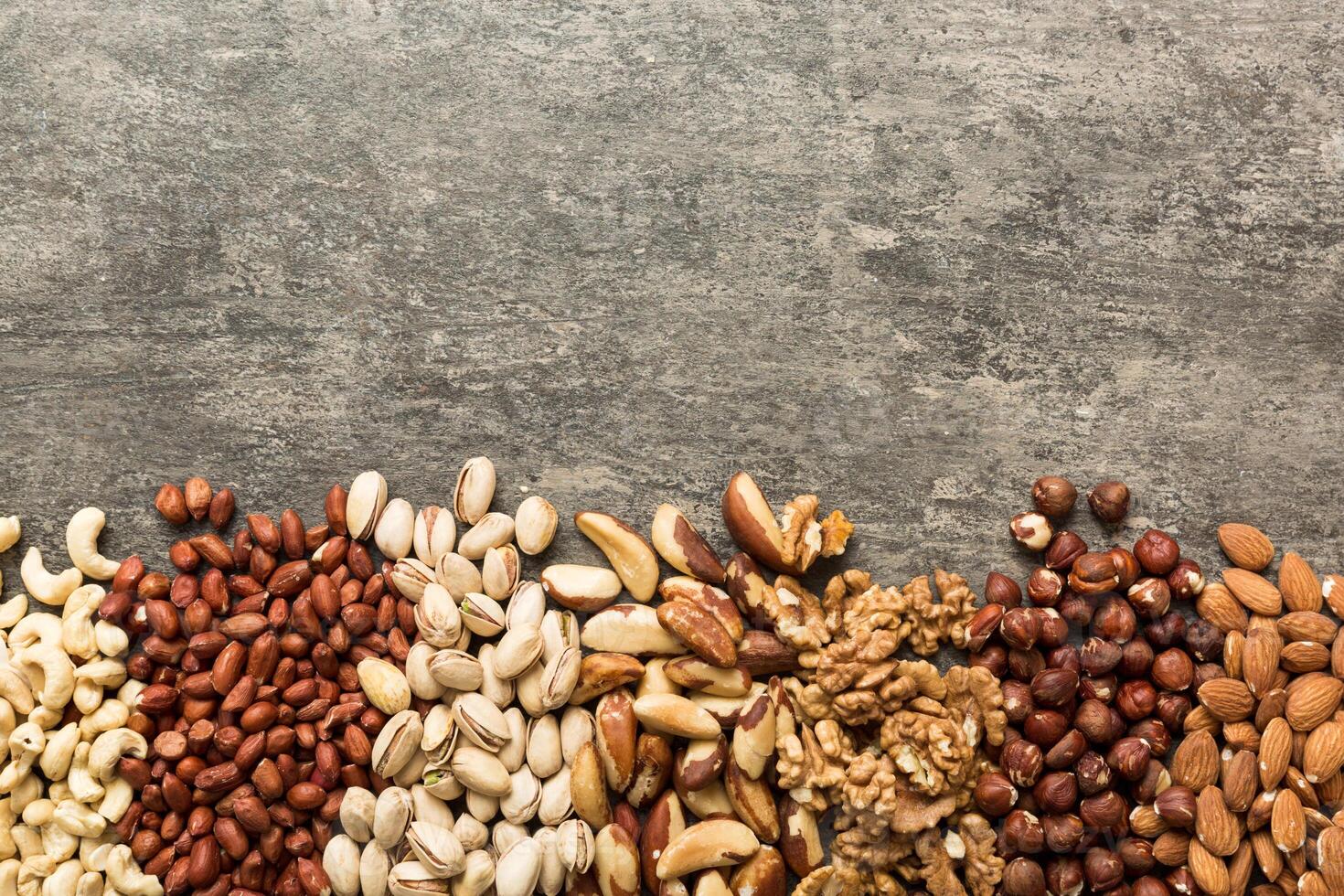 different nuts frame background. flat lay with vopy space. Walnut, pistachios, hazelnuts and cashews photo
